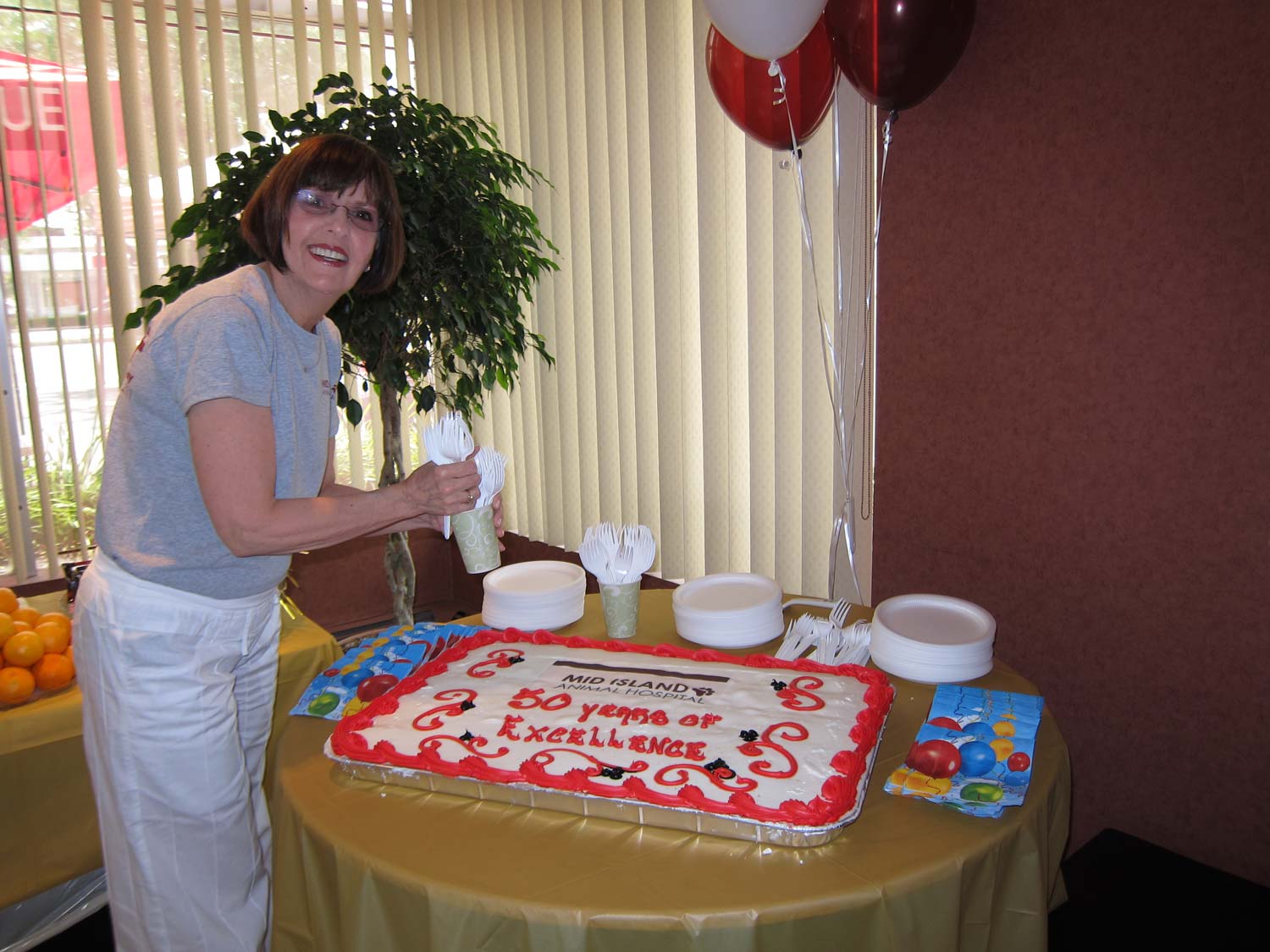a person standing next to a table with a cake