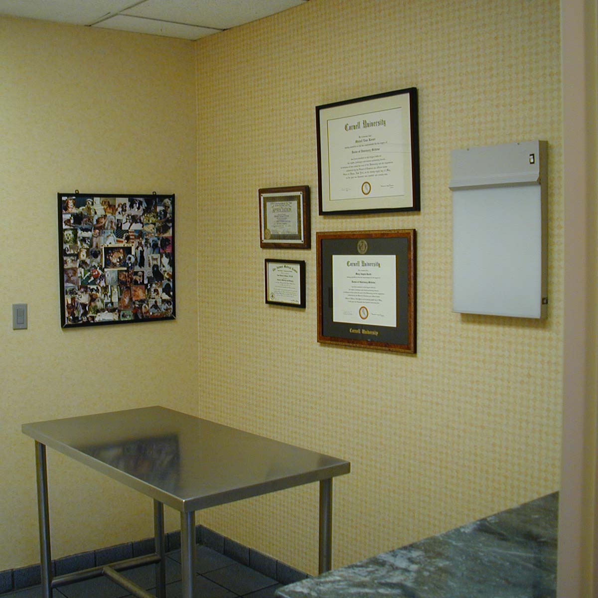 a room with a table and framed pictures on the wall